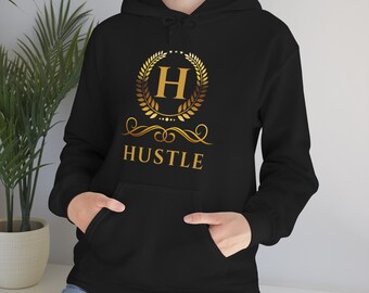 May include: Black hoodie with a gold graphic of a letter H inside a laurel wreath with the word "HUSTLE" below it.