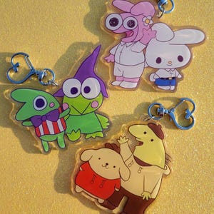 Sanrio x lächelnde Freunde Schlüsselanhänger | Kawaii Cartoon inspiriert Anhänger | Für Rucksäcke, Geldbörsen, Schlüsselbänder, Ita Taschen