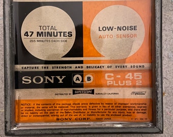 Op de afbeelding: Een vintage audiocassette met het label "SONY C-45 PLUS 2 HIGH FIDELITY" met een totale opnametijd van 47 minuten (235 minuten per zijde). De cassette heeft een automatische ruisonderdrukker en wordt gedistribueerd door Superscope, Sunvalley Californië.