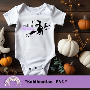 May include: White baby onesie with a black silhouette of a witch flying on a broomstick with a black cat. The text "resting witch face" is written in purple on the onesie.