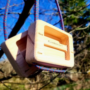 May include: Two wooden climbing holds with a rope loop. The holds are rectangular with a cutout in the center. The larger hold is 18 mm and the smaller hold is 17 mm. The holds are labeled "CLIMBCRAFT".