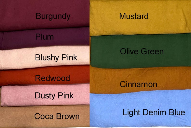 May include: A stack of fabric swatches in various colors, including burgundy, plum, blushy pink, redwood, dusty pink, coca brown, mustard, olive green, cinnamon, and light denim blue. Each swatch has a color name label.