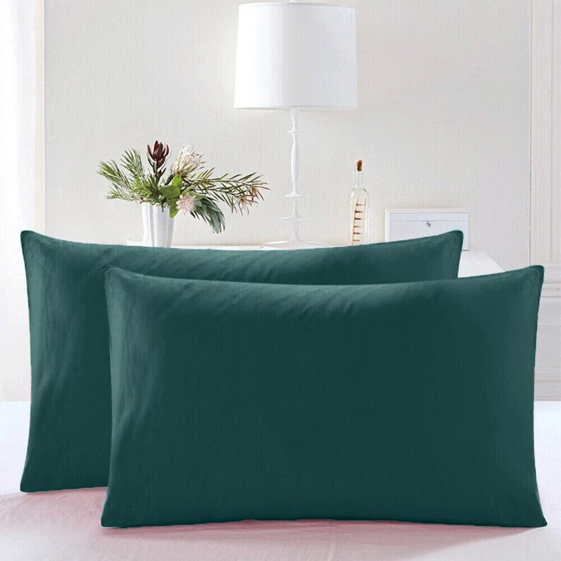 May include: Two teal blue pillowcases, one on top of the other, with a white background.