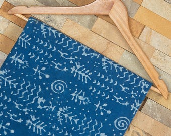 May include: A blue fabric with a white pattern of abstract shapes and swirls. The fabric is hanging on a wooden hanger.