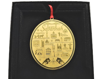 May include: Gold-colored metal ornament depicting a map of Savannah, Georgia. The ornament features various landmarks including the City Hall, City Market, and Forsyth Park. The text "The City of Savannah" is inscribed at the top of the ornament.