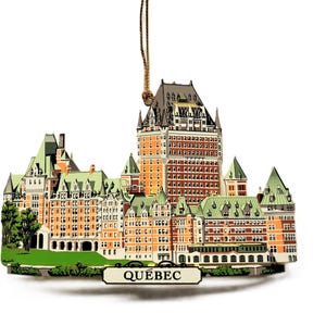 May include: A wooden ornament depicting the Chateau Frontenac hotel in Quebec City, Canada. The ornament is painted in shades of brown, green, and white, with the words "QUEBEC" printed on a banner below the building.