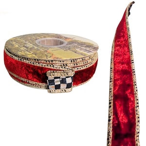 May include: A spool of red velvet ribbon with gold trim and a black and white checkered accent. The ribbon is displayed with a length of the ribbon unfurled, showcasing its texture and design.