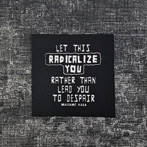 May include: A square black fabric patch featuring white screen-printed text that reads: LET THIS RADICALIZE YOU RATHER THAN LEAD YOU TO DESPAIR, with the name MARIAME KABA printed in smaller white letters at the bottom of the patch.