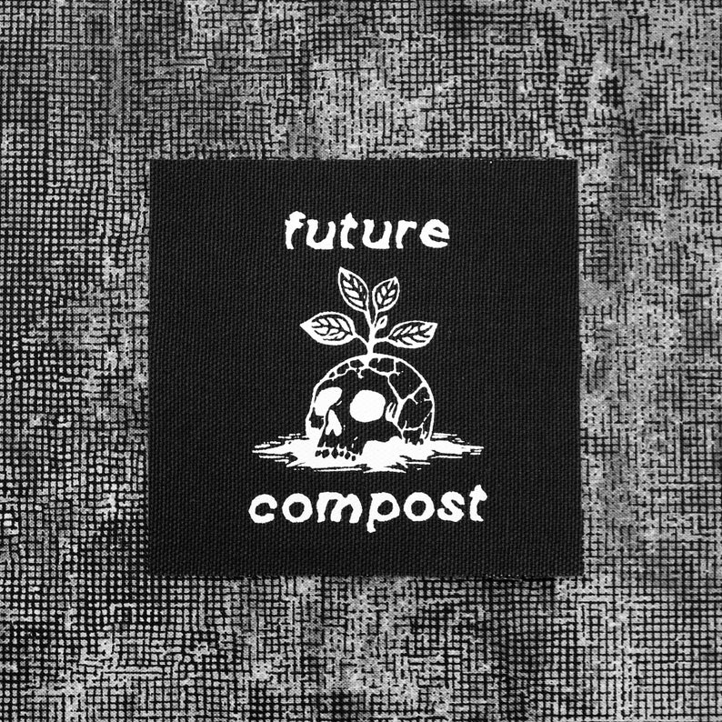 Pu&ograve; includere: Toppa nera con testo e grafica bianchi. Il testo recita "future compost". La grafica &egrave; un teschio con una pianta che cresce dalla cima.