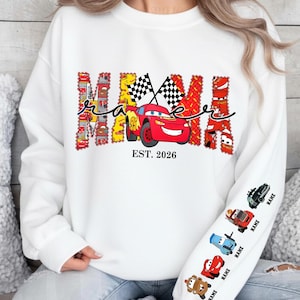 May include: White sweatshirt with a colorful "Mama Race" design featuring a red race car and checkered flags. The text "EST. 2026" is below the car. The sleeve has cartoon race cars with the word "NAME" printed below each.