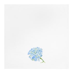 Op de afbeelding: Witte vierkante stof met een aquarel illustratie van een blauwe en groene hortensia bloem. De bloem staat in het midden onderaan en heeft een groene stengel.