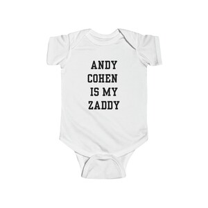Puede incluir: Un body blanco para bebé con texto negro que dice "ANDY COHEN IS MY ZADDY".