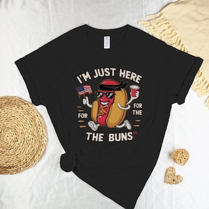 I'm Just Here For The Buns | Cartoon Hot Dog Sunglasses American Flag Drink Tee - Humorous Casual Graphic Tee for Funny T-Shirt Fans