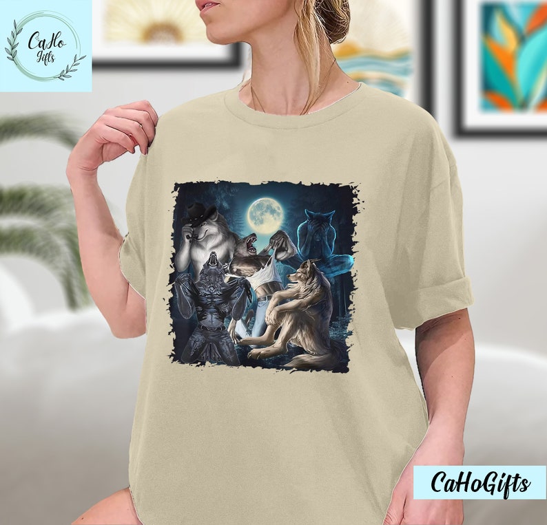 May include: A beige t-shirt with a graphic print of a group of wolves howling at the moon. The wolves are depicted in a dark, shadowy forest setting.