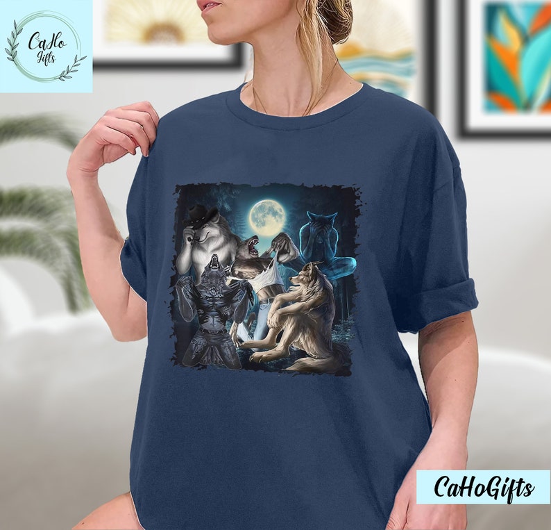 May include: A navy blue t-shirt with a graphic of a group of werewolves howling at the moon. The werewolves are depicted in a dark forest setting.