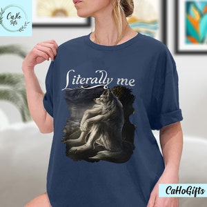 May include: A navy blue t-shirt with a white wolf illustration and the text "literally me" printed on the front.