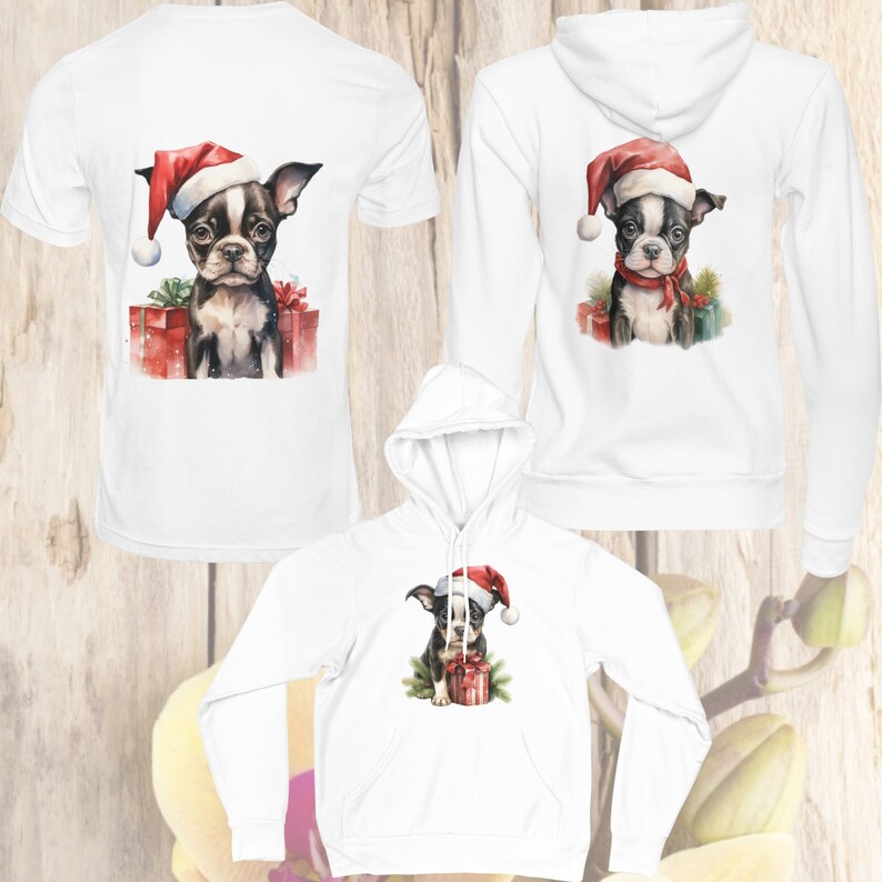 May include: Three white shirts with a Christmas-themed design featuring a black and white Boston Terrier puppy wearing a Santa hat and holding a red gift box. The shirts are available in a t-shirt and hoodie style.
