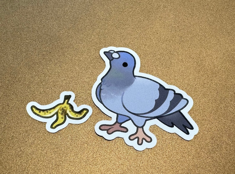 May include: A blue and gray pigeon sticker with white eyes and a yellow banana peel sticker.