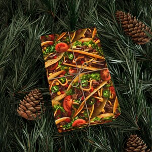 May include: Gift-wrapped present featuring a colorful taco pattern, tied with twine. The wrapping paper displays a vibrant design of tacos with tomatoes, lettuce, and jalapeños. The gift is set against a backdrop of pine needles and pine cones.