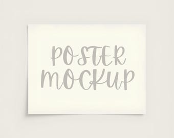 Puede incluir: Maqueta de póster rectangular con las palabras "POSTER MOCKUP" en una fuente gris claro, de estilo manuscrito. El póster está centrado sobre un fondo color crema.