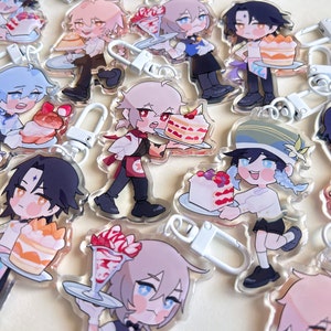 Puede incluir: Colección de llaveros acrílicos con personajes de estilo anime sosteniendo postres. Cada llavero tiene un cierre plateado. Los personajes se representan con varios peinados y atuendos, y los postres incluyen pasteles y parfaits.