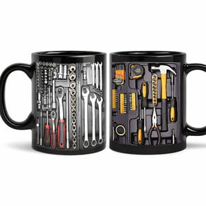 May include: A black ceramic mug featuring a printed graphic of a tool kit. The left side shows a monochrome layout of wrenches and sockets, while the right side displays a colourful arrangement of a hammer, pliers, screwdrivers, and tape measure.