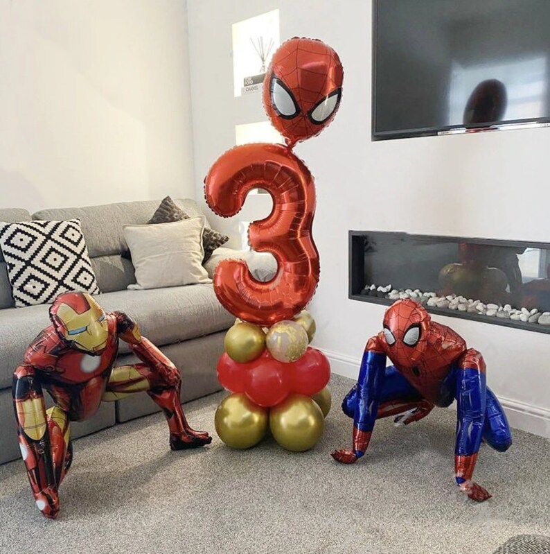 Puede incluir: Decoraciones de globos rojos y azules para una fiesta de cumplea&ntilde;os. Los globos tienen forma de n&uacute;mero 3, Spiderman y Iron Man.