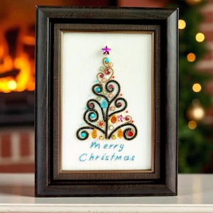 May include: A framed embroidery art piece featuring a stylised Christmas tree made of dark green swirling thread, accented with colourful beads and crystals, topped with a purple star, and the text Merry Christmas stitched in blue thread.