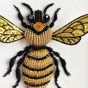 Detailed beaded honey bee embroidery displayed as framed insect decor