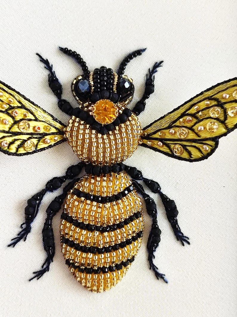 Detailed beaded honey bee embroidery displayed as framed insect decor