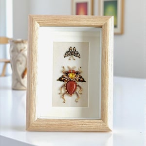 Decoración de pared con insectos fantásticos enmarcados, extraño insecto disecado, arte caprichoso de escarabajo en una pequeña caja de sombra.