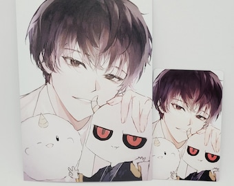 May include: Two art prints featuring a manga-style illustration of a person with dark hair and a white shirt, holding two cartoon characters. The characters are white with red eyes and a black outfit.