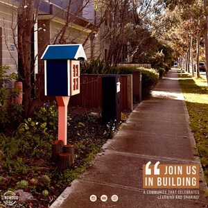 May include: A small, dark blue wooden book exchange box with a peaked roof and a glass-paned door, mounted on a light-colored post supported by three short log segments. The text "JOIN US IN BUILDING A COMMUNITY THAT CELEBRATES LEARNING AND SHARING!" is visible.