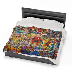 May include: A white bed with a black headboard and a duvet cover featuring a collage of vintage comic book covers featuring Spider-Man. The covers are in various colors, including red, blue, yellow, and green. The text on the covers includes "Spider-Man", "Amazing Spider-Man", and "Marvel Tales".