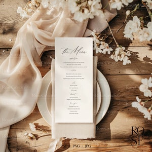 May include: A wedding menu card with a simple, elegant design. The card is white with black text and features a handwritten font for the title "The Menu". The menu includes appetizers, wine, entrees, sides, coffee, dessert, and beverages.