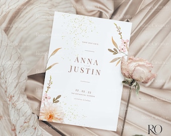 May include: A white save the date card with gold glitter and floral illustrations. The text reads "Save Our Date, Anna and Justin, 22.02.22, The Botanical Garden, Invitations to follow."
