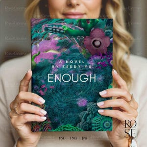 A lifestyle photograph of a woman softly smiling while holding a blank, cream-colored A5 hardcover book directly in front of her. She is holding the book with both hands, showcasing a delicate rose gold watch and rings. The lighting is soft and natural, creating a feminine, high-end aesthetic.