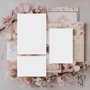May include: A styled stock photo featuring a collection of blank cards and stationery, surrounded by pink and cream-colored flowers and decorative elements. The image has a soft, romantic aesthetic, perfect for showcasing designs or announcements. The bottom right corner displays the text "ROSE CREATIVE".