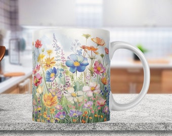 May include: White ceramic mug with a colorful floral design. The design features a variety of flowers in shades of pink, blue, yellow, and orange. The flowers are arranged in a field-like pattern.