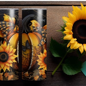 May include: Two 20 oz. stainless steel tumblers with a fall-themed design. The design features pumpkins, sunflowers, and butterflies in shades of orange, yellow, and black. The tumblers are set against a dark background.