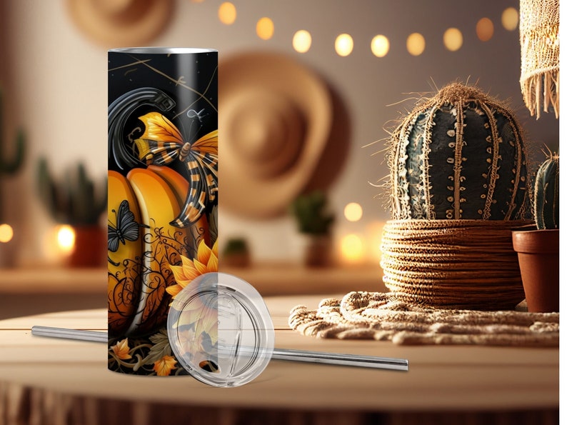 May include: A stainless steel tumbler with a pumpkin and butterfly design. The tumbler features a black background with orange pumpkins, yellow sunflowers, and butterflies. A clear lid and a silver straw are included.