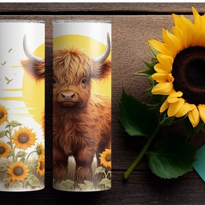 Puede incluir: Dos vasos aislados blancos con un dise&ntilde;o de vaca de las Tierras Altas y girasoles. Uno presenta una vaca contra un sol amarillo, el otro tiene girasoles y p&aacute;jaros. Un gran girasol est&aacute; al lado.