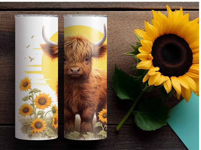 Puede incluir: Dos vasos aislados blancos con un dise&ntilde;o de vaca de las Tierras Altas y girasoles. Uno presenta una vaca contra un sol amarillo, el otro tiene girasoles y p&aacute;jaros. Un gran girasol est&aacute; al lado.
