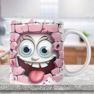 May include: White ceramic mug with a pink brick wall design. A cartoon face with big eyes and a tongue sticking out is breaking through the wall.