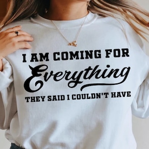 May include: White sweatshirt with black text that reads "I am coming for everything they said I couldn't have".