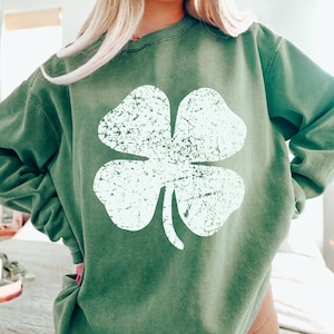 Peut inclure: Un sweat-shirt vert avec un graphique de tr&egrave;fle &agrave; quatre feuilles blanc vieilli.