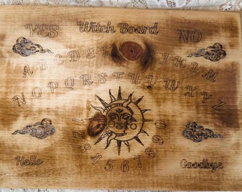 May include: A wooden Witch Board with the words "Yes" and "No" at the top. The board features the alphabet, numbers, and the words "Hello" and "Goodbye". A sun and moon design is in the center.