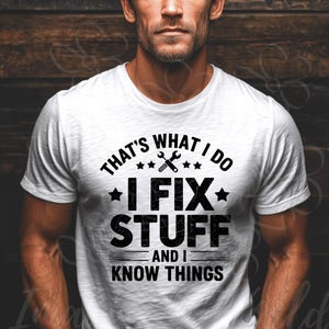 May include: White t-shirt with the text "THAT'S WHAT I DO, I FIX STUFF, AND I KNOW THINGS" in black. The design includes a wrench and star graphic. The shirt is a crew neck style.