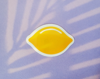 May include: A yellow lemon sticker with a white outline on a purple background with a white leaf pattern.