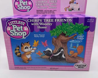 May include: A Littlest Pet Shop playset box featuring a raccoon, skunk, and squirrel with a tree and butterflies. The box reads "Chirpy Tree Friends with Woodsy Home" and "Chatter Pets". Ages 4 and up.